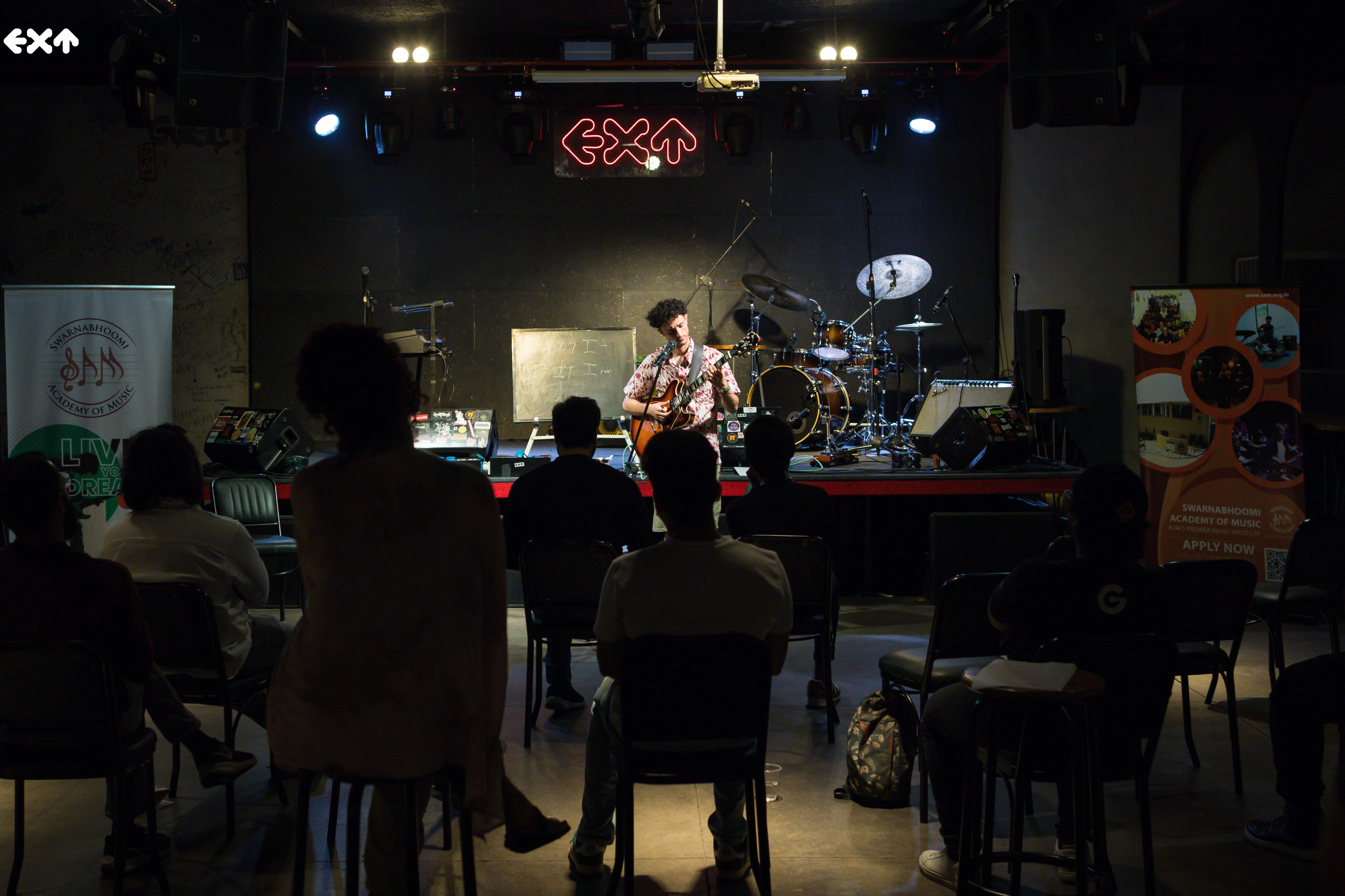 Lucas Baret en concert, guitare électrique à la main, sur la scène d'un club